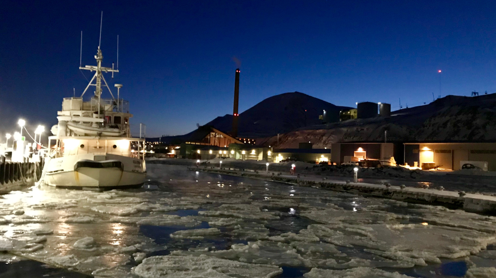 Kleiner Hafen in Longyearbyen in der Dunkelzeit mit Eis. 