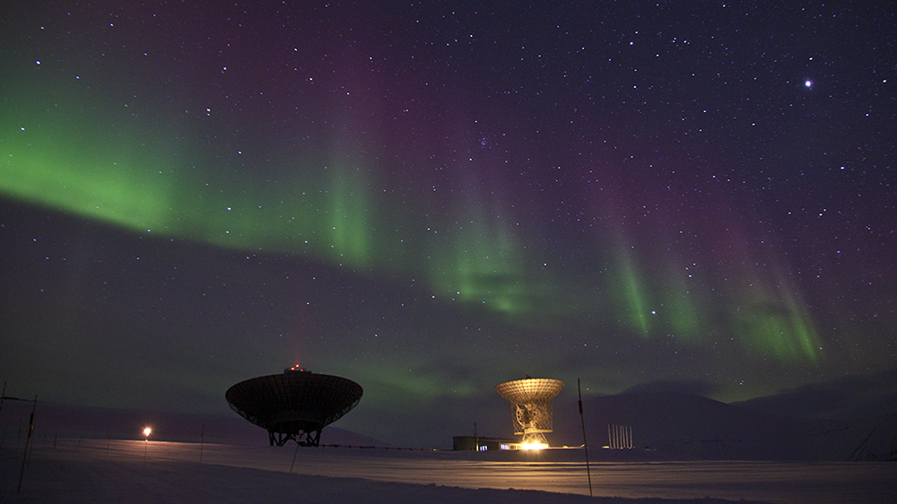 Northern lights above the satellite dishes of EISCAT on Svalbard