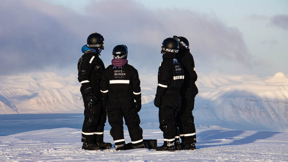 Vier Spitzbergen-Reisen-Gäste in Schneemobilanzügen