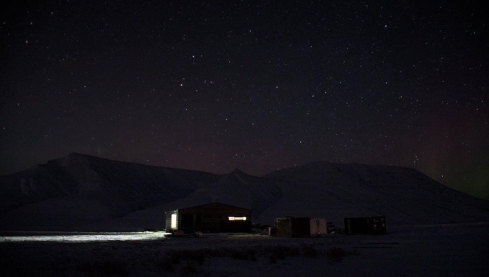 Eine Hütte im Adventdalen vor dem Nachthimmel