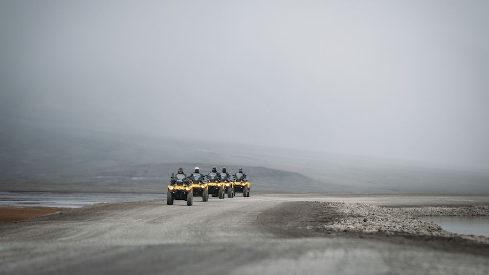Five ATVs on a gravel road