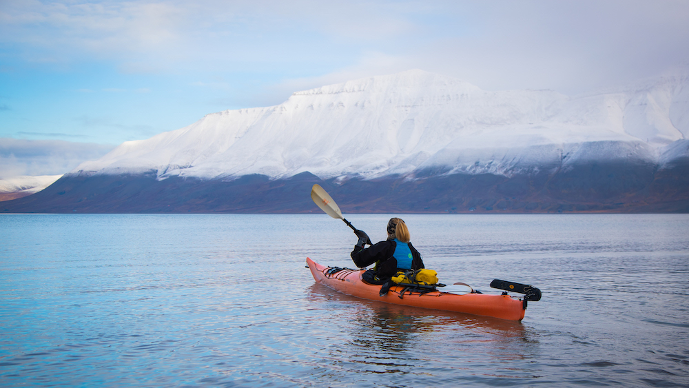 A kayak in the Adventfjorden near Longyearbyen in front of snowy mountains