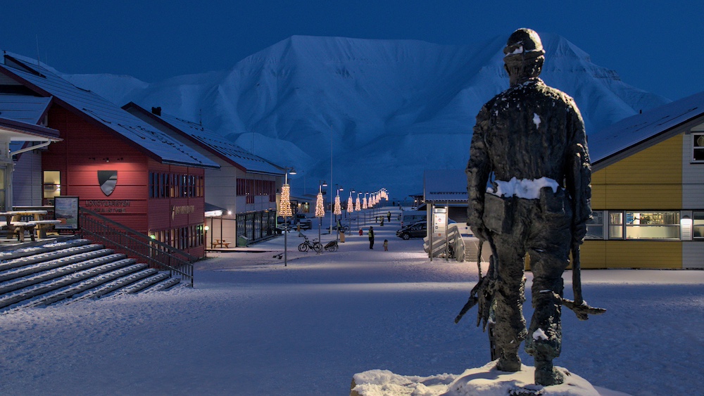 Minenarbeiter-Denkmal in Longyearbyen von hinten mit Blick auf die Berge