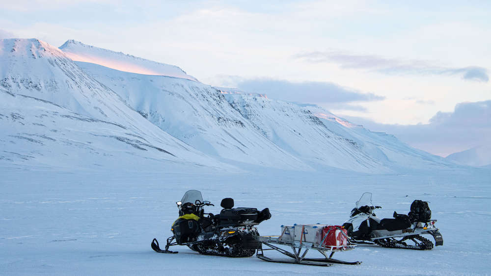 Two snowmobiles in the snowy landscape of Svalbard