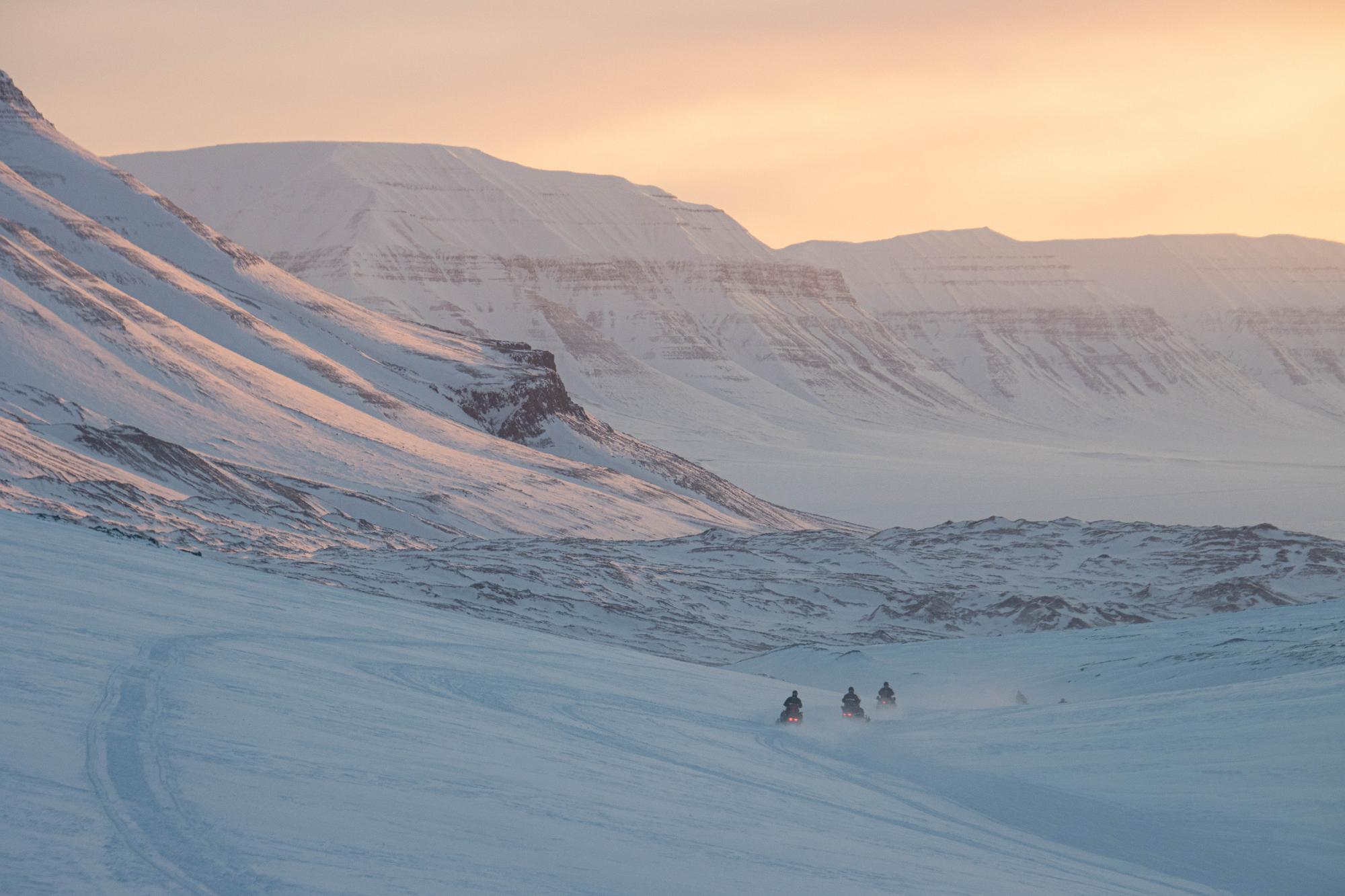 Schneescooter fahren am Abend auf Spitzbergen