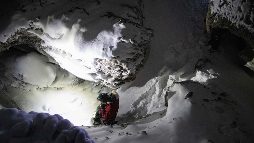 Person bei einer Schneewanderung in einer Eishöhle